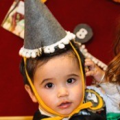 child wearing finished hat and badge