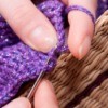 woman crocheting with purple yarn