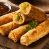 eggrolls on plate with sauce on the side