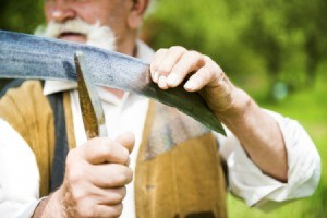 Man Sharpening a Scythe