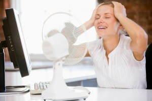 Woman Using Fan to Cool Off