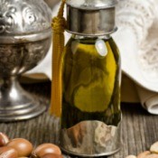 argan oil in glass container with fruits