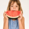 girl eating watermelon with juice dripping on blouse