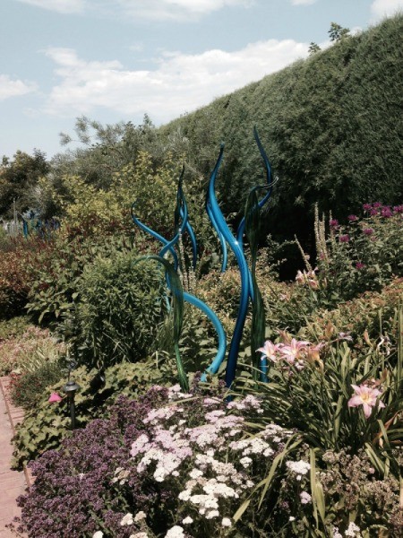 serpentine blue and black shapes among the lilies and flowers