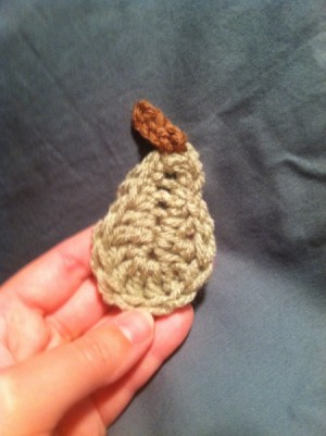 hand holding crochet pear