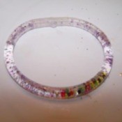 flexible tubing filled with water, glitter, and beads made into a bracelet