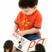 young boy looking at an alphabet book