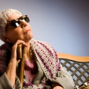 older blind woman sitting on a bench