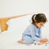 little girl in pajamas on bed coloring