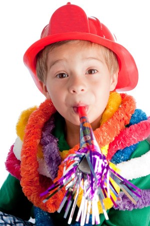 boy in fireman's helmet with party horn