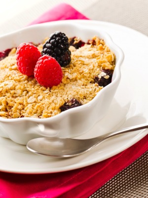 mixed berry cobbler in  white scalloped dish
