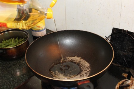 adding oil to wok