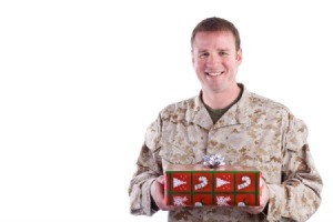 young man in camos holding a Christmas gift