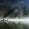 man in canoe with fog over lake