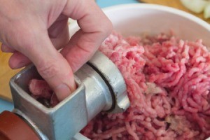countertop meat grinder and bowl of ground meat
