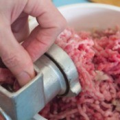 countertop meat grinder and bowl of ground meat