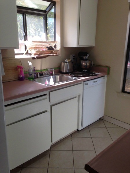 view of pink countertop and cabinets
