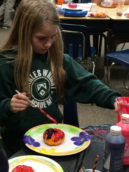 kid painting pumpkin