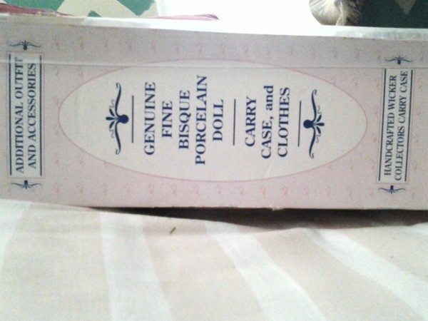 The side of the box of a porcelain doll.