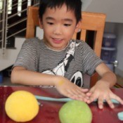 boy rolling a rope of dough