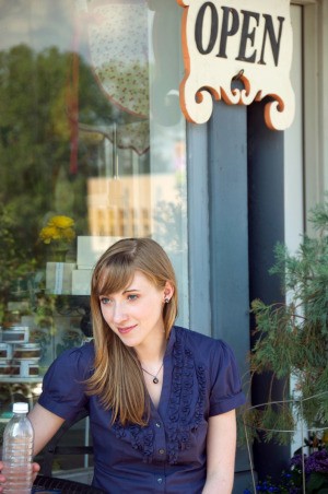 woman sitting outside small shop