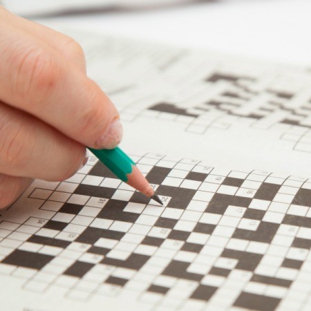 a person doing a crossword in pencil