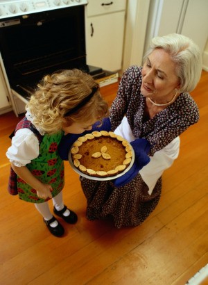 grandmother and child with pumpkin pie hot from the oven
