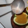 Pouring the flavored Jello into the apple halves.