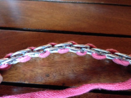 Side close up of soda tab bracelet made from soda tabs and a pink shoelace