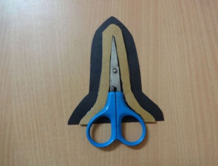 demonstrating how scissors fit into the cardboard