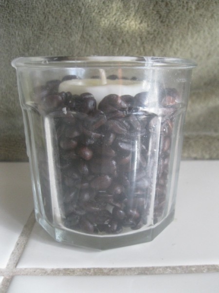 side view of the beans next to the base candle in glass mold
