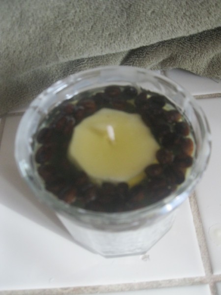 view down of melted wax over beans next to base candle