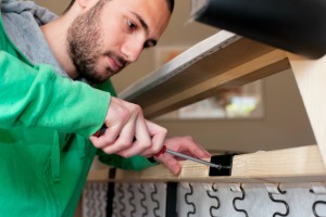 Man Repairing a Broken Couch Frame