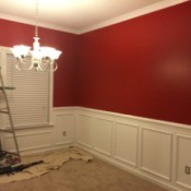 dining room with red walls and white wainscoating
