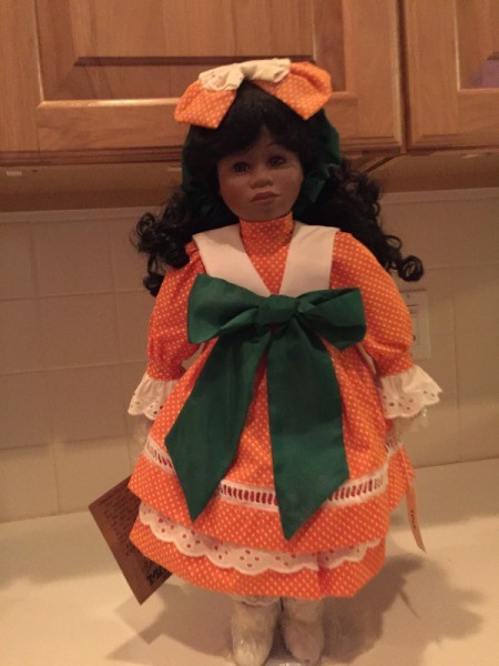 doll wearing dress with large green bow