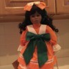 doll wearing dress with large green bow