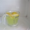 Lemon and Baking Soda for Cleaning Microwave - A measuring cup with cut up lemons, water and baking soda.