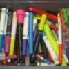 A box of markers with saved marker caps.