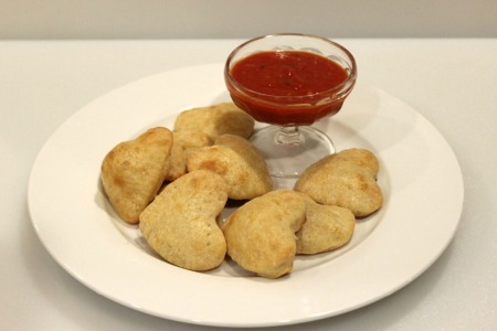 heart shaped calzones on plate with sauce for dipping