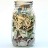 A jar full of bills and coins.