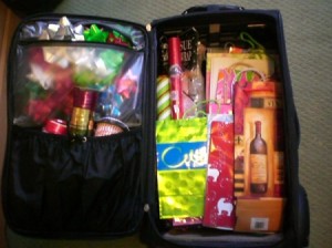 Open suitcase with gift wrap stored inside.