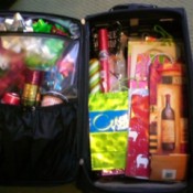 Open suitcase with gift wrap stored inside.