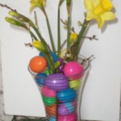 glass vase with daffodils and colored eggs