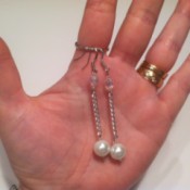 finished pearl earrings on woman's palm