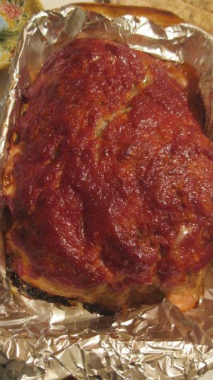 A meatloaf topped with chili sauce.
