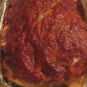 A meatloaf topped with chili sauce.