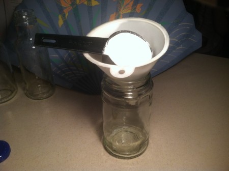 Baking soda being measured into a funnel.