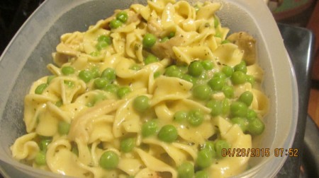 A main dish of chicken noodles and peas.