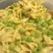 A main dish of chicken noodles and peas.