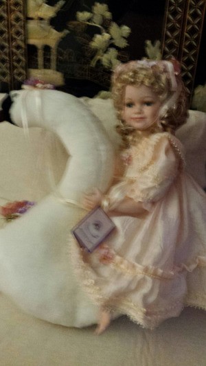 doll sitting on a swan